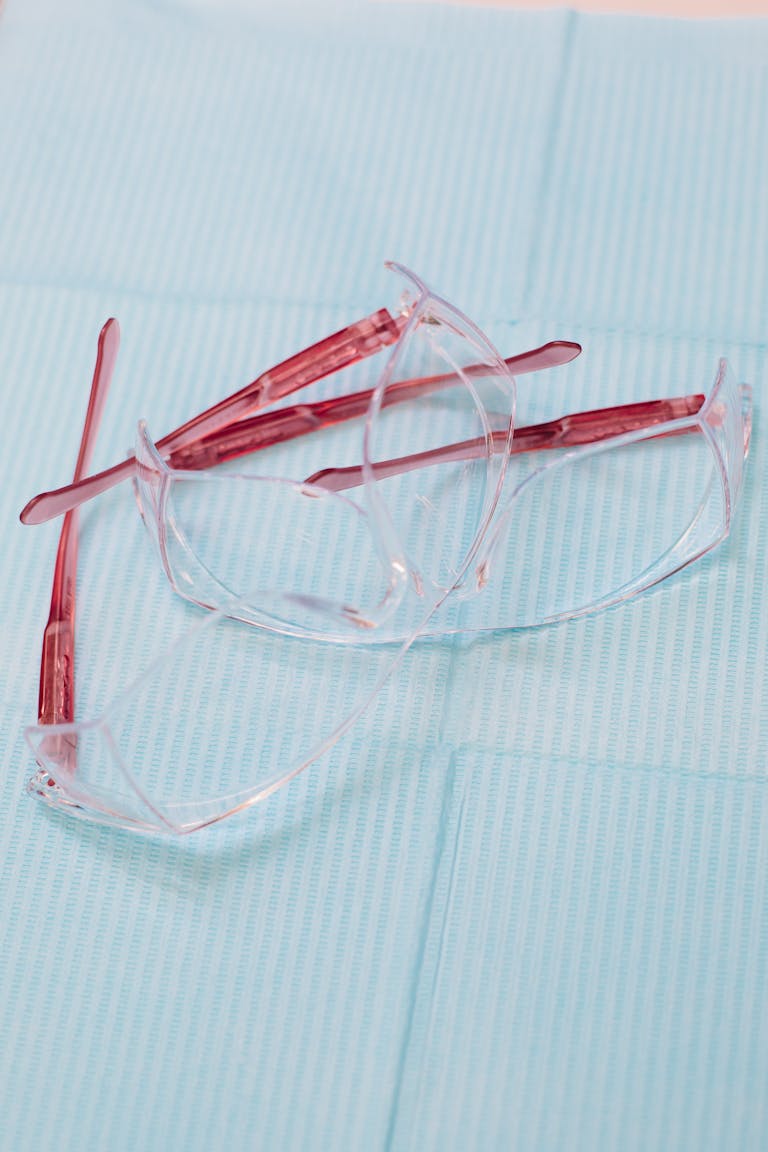 Close-up of transparent protective eyewear on a blue medical cloth, emphasizing healthcare.